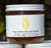 a glass jar of honey with the Bee Bee Qute logo